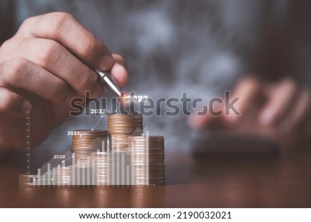 Businessman drawing increasing graph with coin stacking for increase financial interest rate and business investment growth from dividend concept.