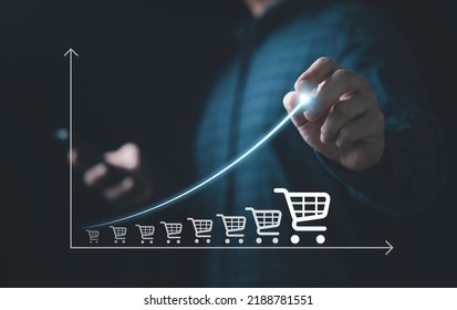 Businessman drawing increasing trend graph of sale volume with bigger shopping trolley cart for  online sale business growth concept. - Shutterstock ID 2188781551