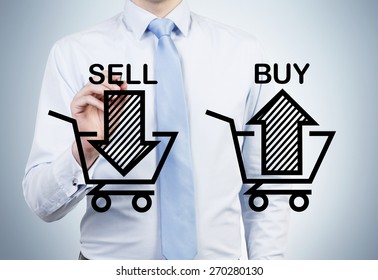 Businessman is drawing 'sell and buy' arrows on the glass screen. A concept of the trader who is forming a portfolio by selling and buying assets.