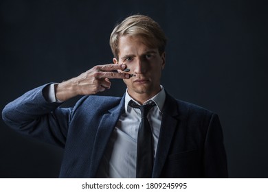 Businessman Draws Two Stripes On His Cheeks, War Paint. Competition In Business, Concept. A Young Man In A Suit And Tie Makes War Paint On His Face