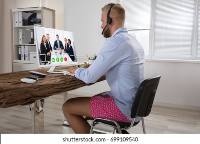 Businessman Dressed In Shirt And Shorts Having Video Call On Computer In The Home Office