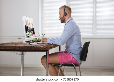 Businessman Dressed In Shirt And Shorts Having Video Call On Computer In The Home Office