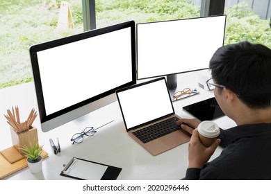 Businessman drinking coffee and working with multiple modern devices.