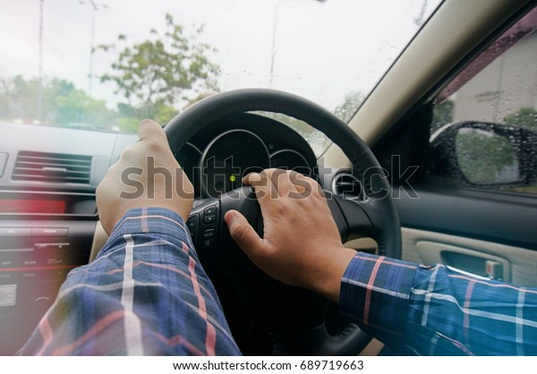 Businessman driving with both hands on\
steering wheel selective focus. safety driving\
concept