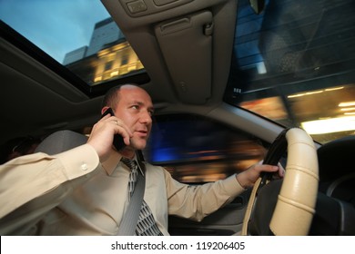 Businessman Driving In Car And Talking On Cell Phone.