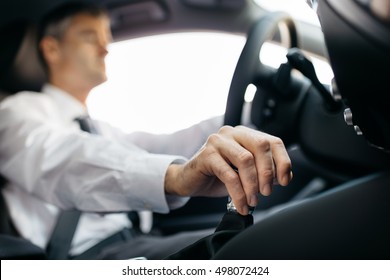 Businessman driving to work, hand shifting the gear stick