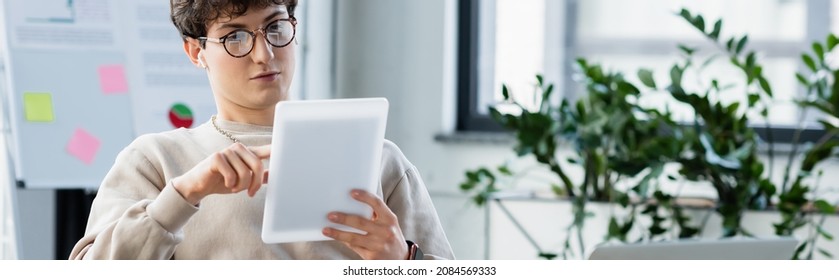 businessman in earphones and eyeglasses using digital tablet in office, banner - Powered by Shutterstock