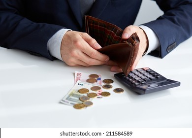 Businessman With Empty Wallet And A Few Coins On The Table