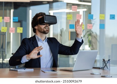 Businessman engaged with virtual reality headset in an office setting. Immersive experience demonstrates technological innovation. Professional appears intrigued and focused, surrounded by office - Powered by Shutterstock