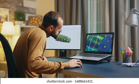 Businessman And Engineer Using Modern Software To Design A Turbine On Computer In Home Office At Night.