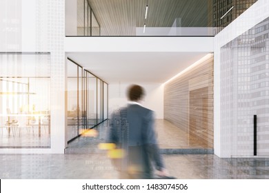 Businessman Entering Modern Office With White And Wooden Walls, Concrete Floor And Conference Room With Glass Doors. Toned Image Double Exposure Blurred