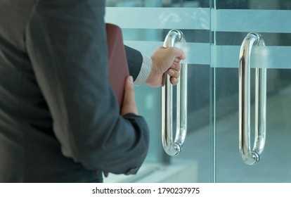 Businessman Entering An Office By Opening Out A Glass Door