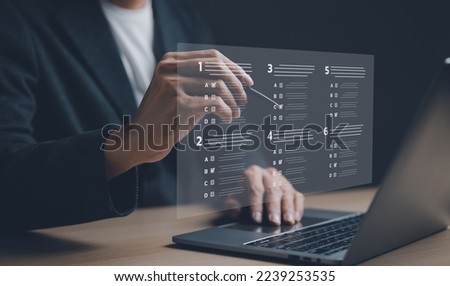 Businessman with evaluating questionnaire on online laptop computer. assessment survey online, choose correct answer in test, questions test, online exam, quiz knowledge, filling out an survey form.
