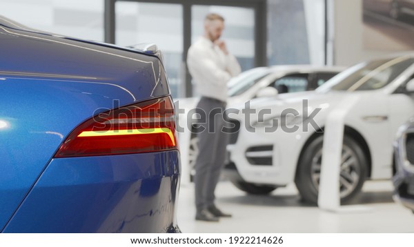 Businessman\
examining cars for sale at car\
dealership