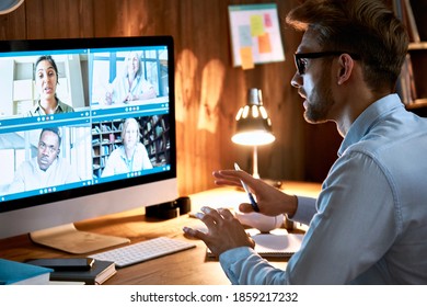 Businessman Executive Leading Virtual Team Meeting On Video Conference Call Using Computer Working From Home Office Talking To Diverse Colleagues In Remote Videoconference Online Social Distance Chat.