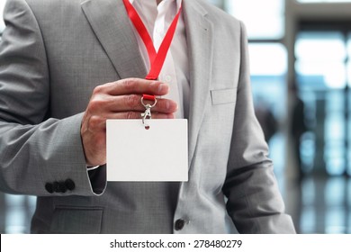 Businessman at an exhibition or conference showing a blank security identity name card on a lanyard