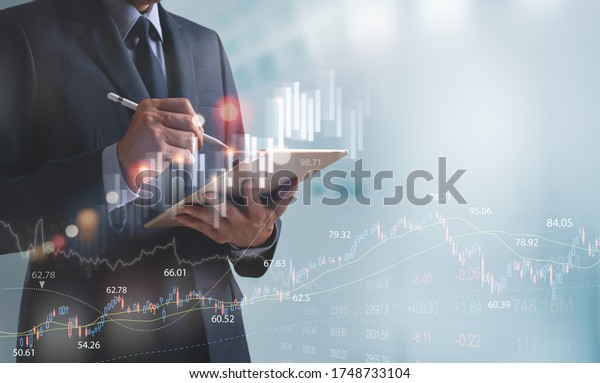 Businessman,\
finance analyst using digital tablet analyzing financial investment\
data, monitoring on stock market report, forex graph, business\
planning and strategy, financial\
background.
