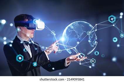 Businessman finger touch earth sphere hologram, wearing vr headset. Augmented reality and cyberspace, future technology. Concept of metaverse and network - Powered by Shutterstock