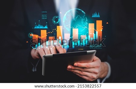 Businessman finger touch tablet in hands. Stock market diagrams, hologram with earth globe, numbers. Colorful chart with dynamic changes. Concept of forex.