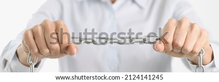 Businessman firmly holds chrome chain in hands. Women in business concept