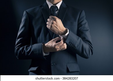 Businessman Fixing Cufflinks his Suit - Powered by Shutterstock