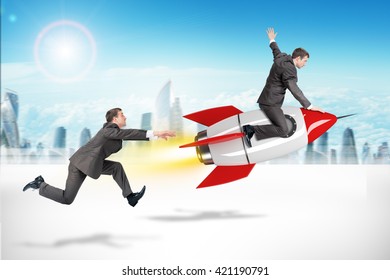 Businessman Flying Away On Rocket From Man On City Background