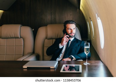 Businessman flying on his private jet - Shutterstock ID 1158453706