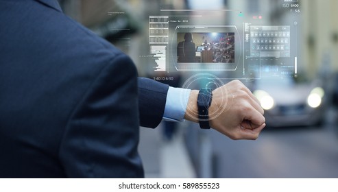 A businessman is followed by a conference on the economy and finance that appears in hologram clock futuristic and technological. Concept: network, conference, technology, augmented reality and future