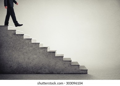 businessman in formal wear walking down the steps  over grey background