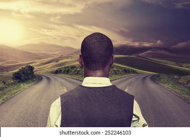 businessman in front of two roads hoping for best taking chance