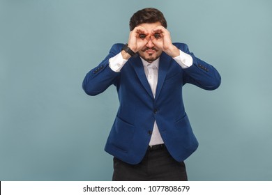 Businessman with funny face looking away in binoculars. Business people concept, richly and success. Indoor, studio shot on light blue background - Powered by Shutterstock