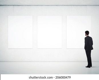 Businessman In Gallery Room Looking At Empty Frames