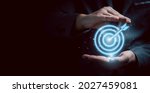 Businessman gesture protecting virtual blue dartboard with arrow ,Business Achievement objective target concept.