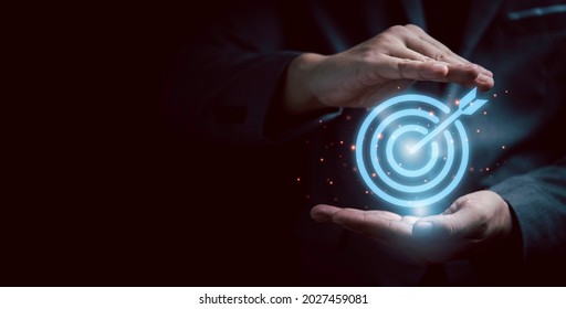 Businessman gesture protecting virtual blue dartboard with arrow ,Business Achievement objective target concept. - Shutterstock ID 2027459081