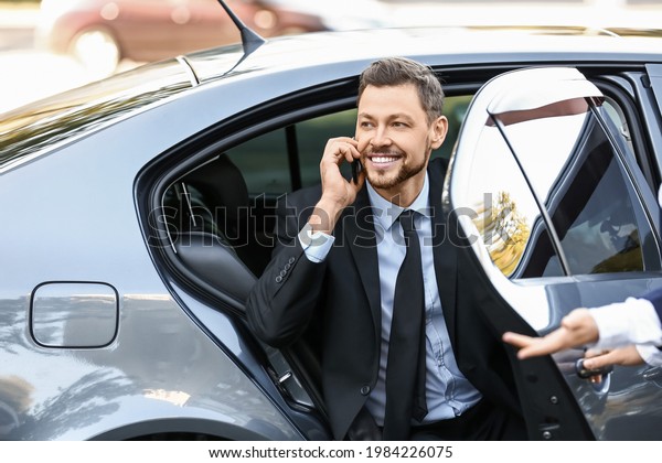 Businessman getting out of\
luxury car