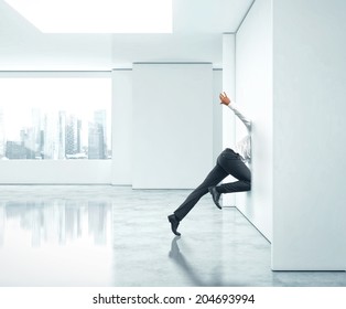 Businessman Getting Stuck Into Office Wall