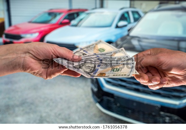 businessman gives money to rent a car for summer\
vacation. finance\
concept