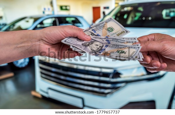 businessman gives money to rent a car for summer\
vacation. finance\
concept