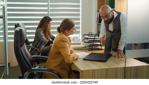 Businessman giving assignments to employee in modern office. Strict man boss giving orders and work tasks to new team member at workplace. - Shutterstock ID 2205425749