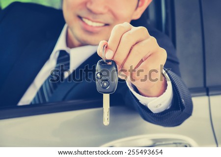 Businessman giving a car key - vintage style color effect