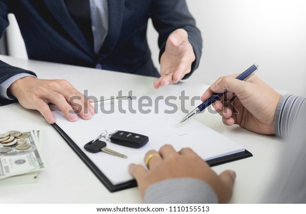 Businessman giving end key to customer after good\
deal agreement. while loan agreement being approved and calculator,\
Buy house concept