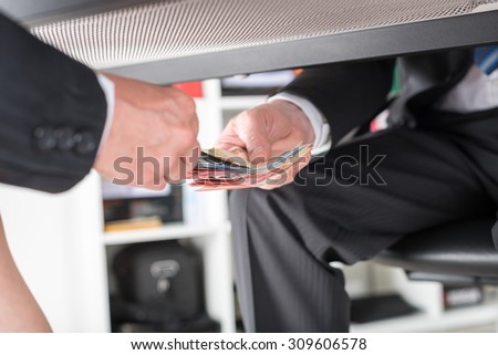 Businessman giving money under a table