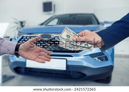 Businessman giving or paying money to dealer at modern car showroom. Insurance or rent new car
