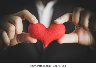 Businessman giving a red heart to a customer on isolated background - customer relationship management