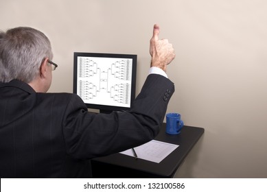 A Businessman Giving Thumbs Up Looking At His March Madness Bracket