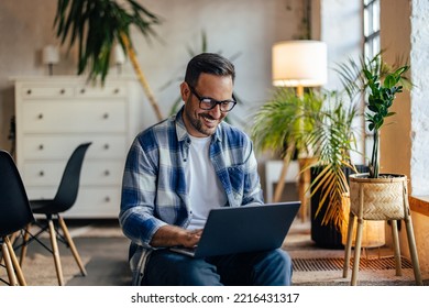 Businessman with glasses on, using a laptop, sitting at the modern office. - Shutterstock ID 2216431317