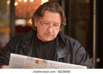 Businessman With Glasses Reading A Newspaper