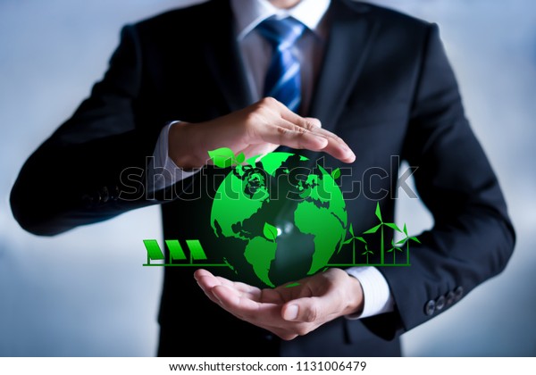 Businessman with a green globe.\
eco-friendly business. Business and environmental\
concepts