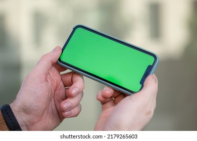 Businessman With Green Screen Chroma Key Smartphone In Office.  Businessperson Using Internet, Social Media, Online Shopping With Mobile Phone Device. Over Shoulder Picture