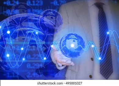 Businessman In A Grey Suit Holding A Glass Globe In Front Of A Stock Ticker Wall With Glowing Waves Global Business Concept